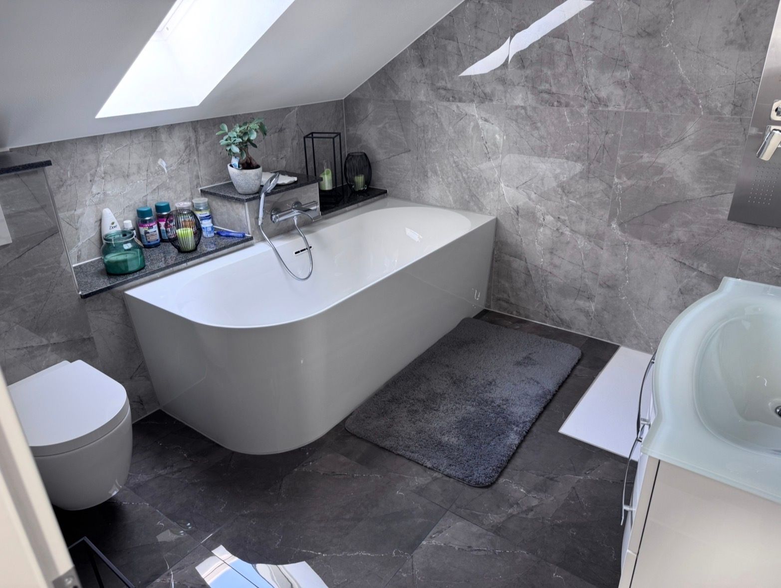 Bad nachher: freistehende Wanne, graue Großformatfliesen, Wand-WC