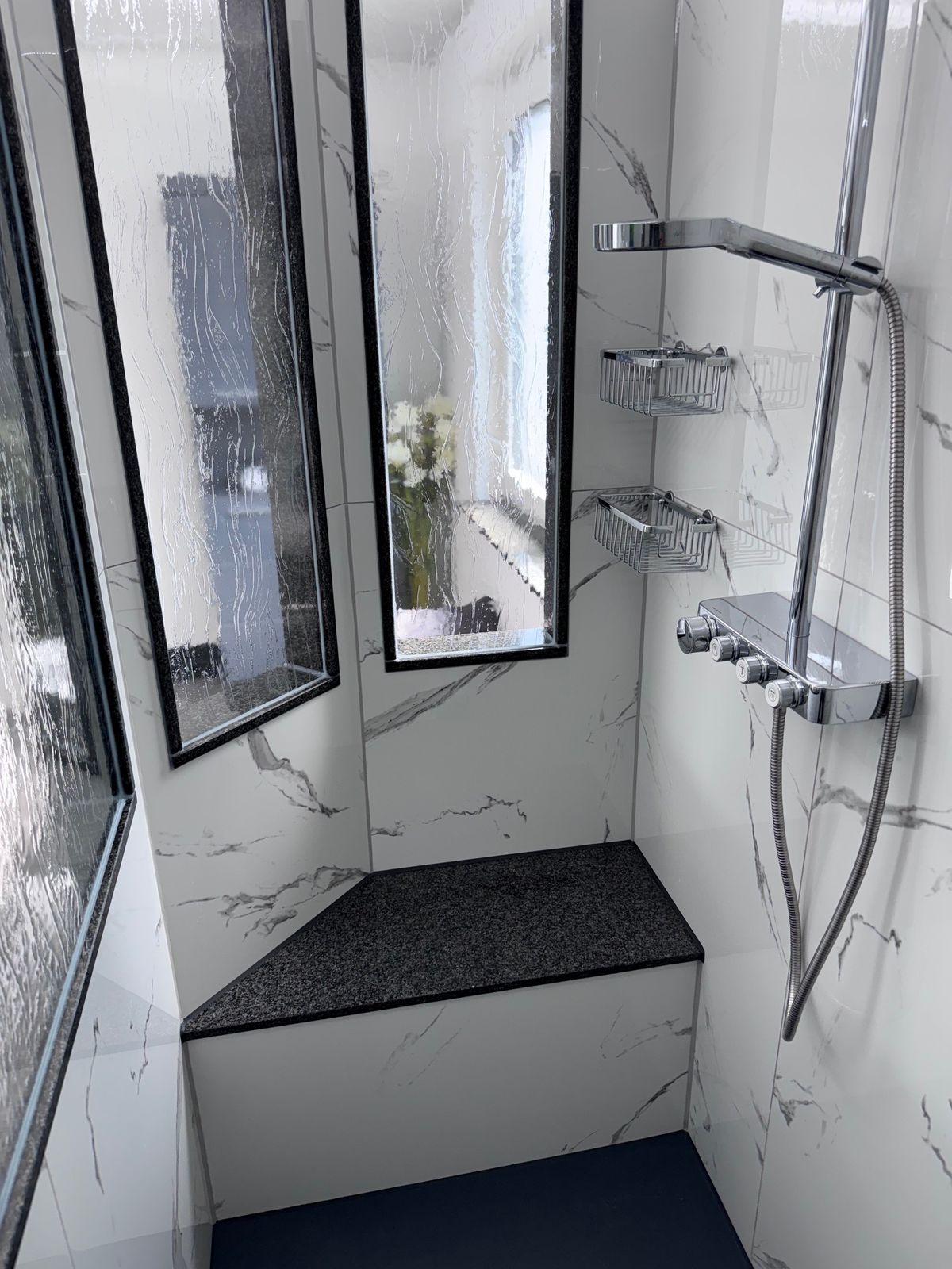 Dusche mit Sitzbank aus Granit und Marmoroptik-Fliesen