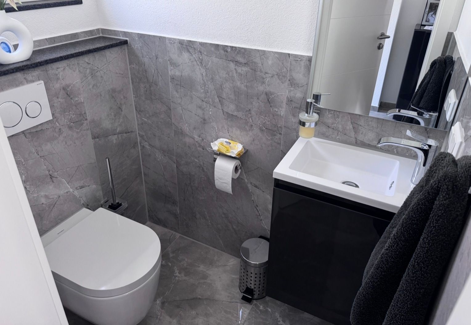 WC nachher: Wand-WC, Waschtisch mit Unterschrank, graue Fliesen
